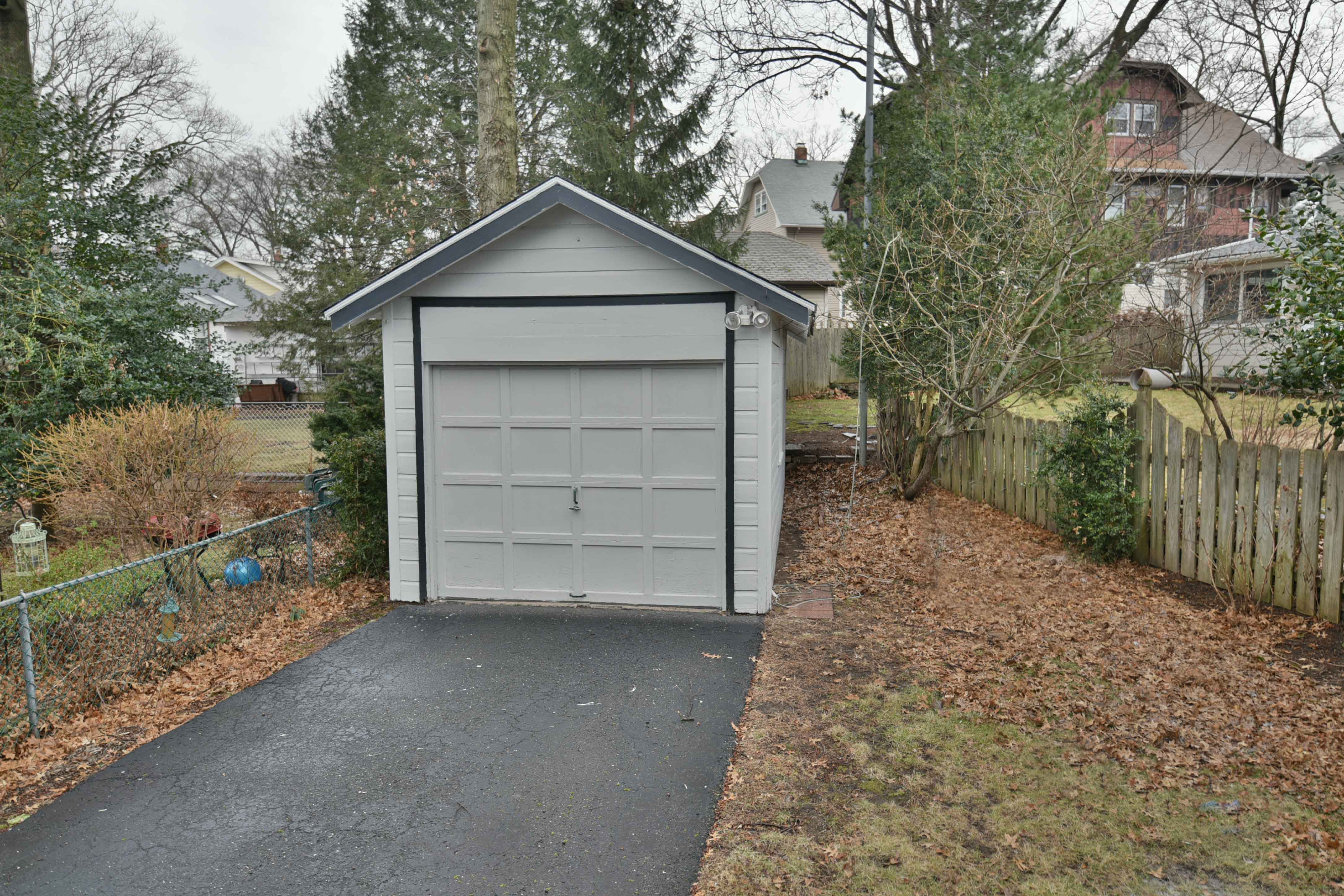 Modern kitchen with barstool seats, white marble countertops and stainless steel hood