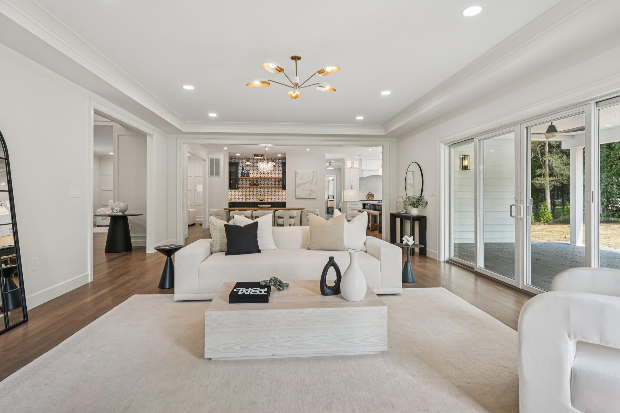 Modern kitchen with barstool seats, white marble countertops and stainless steel hood